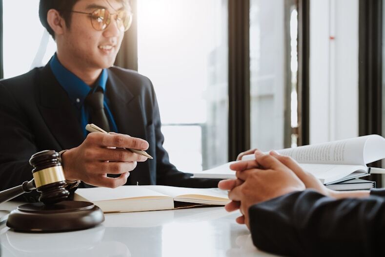 Two people meeting across a desk with a gavel
