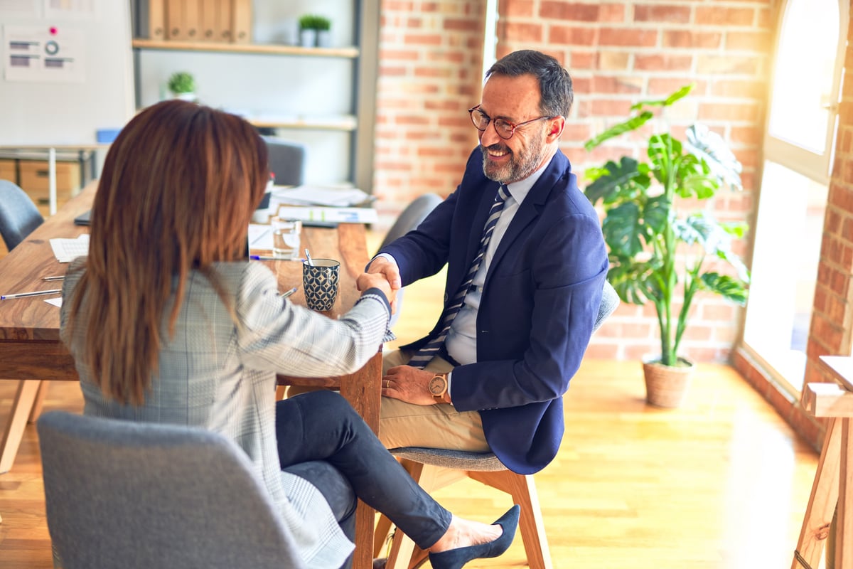 Two people shaking hands in an office